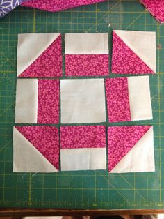 the blocks are cut into squares and laid out on a green cutting board with pink fabric