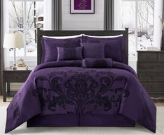 a bed with purple comforters and pillows