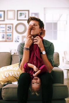 a man is sitting on the back of a woman's head as they both look at each other