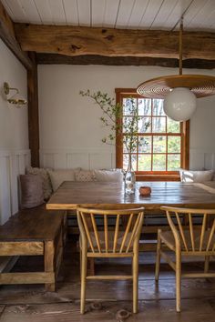 a wooden table sitting under a window in a room