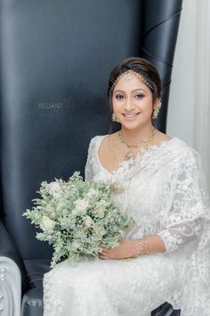 a woman sitting in a chair holding a bouquet