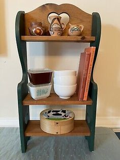 an old wooden shelf with bowls, cups and other items on it's shelves