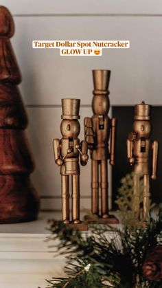 three wooden toy figurines sitting on top of a table next to pine cones