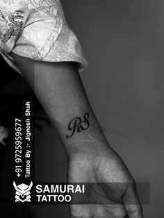 a black and white photo of a person's arm with a tattoo on it