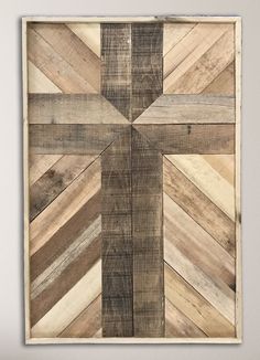 a cross made out of wooden planks hanging on a wall