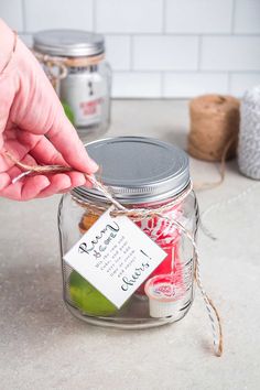 a person holding a stick in a glass jar