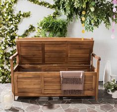 a wooden bench sitting in front of a plant