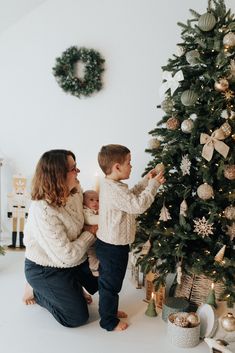 a mother and son decorating a christmas tree