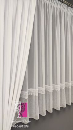 white curtains with lace trim hanging on the wall