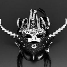 Jingle your way into an event and entertain an audience with the black/silver Jester mask. The glossy embroidery will brighten the party. The twirling black/silver mask has horns jutting out from the sides and the feathery earrings ads an exotic touch. Mask Ball Party, Animal Horns, Silver Masquerade Mask, Masquerade Mask Women, Jester Mask, Mask Ball, Silver Mask, Party Mask, Ball Party