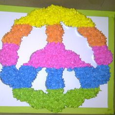 a peace sign made out of flowers on top of a white board with green trim