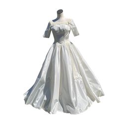 a white wedding dress on a mannequin headdress with sleeves and laces