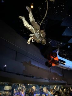 two people are suspended upside down in the air with their hands up and feet apart