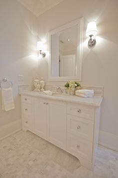 a white bathroom with two sinks and mirrors