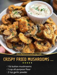 a white plate topped with fried mushrooms next to a bowl of dip