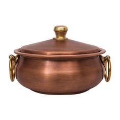 a large copper pot with two handles and a lid on the side, sitting against a white background