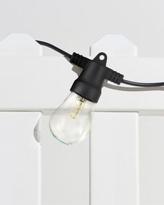 the light bulb is plugged into the wall with a black cord attached to it