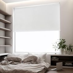 a bed sitting under a window next to a white book shelf with books on it