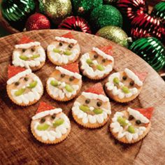 small cookies decorated like santa claus are on a wooden platter