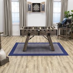 a living room filled with furniture and a wooden foo - pong table on top of a blue rug