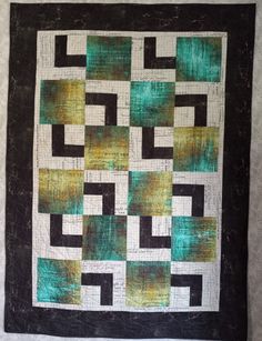 a green and black quilted wall hanging