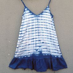 a blue and white dress hanging on the side of a wall next to a hat