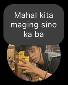 a man holding a cell phone in front of his face with the words mahl kita maging sino ka ba