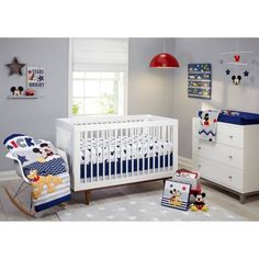 a baby's room with mickey mouse crib, dresser and bedding set