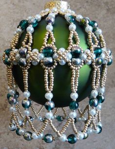 a green ornament with beads and pearls