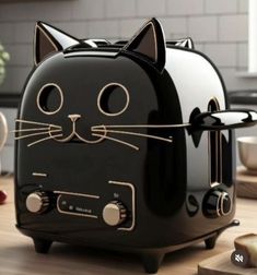 a black cat toaster sitting on top of a wooden table