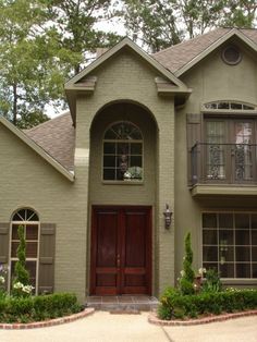 a large house with two red doors and brown shutters