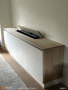 an entertainment center in the corner of a room with carpet on the floor and white walls