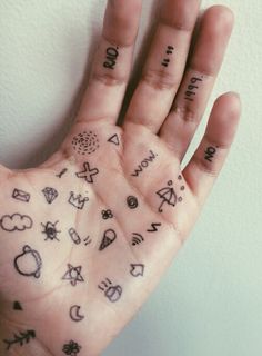 a person's hand with tattoos on it and words written all over the palm