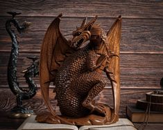 a wooden dragon statue sitting on top of an open book