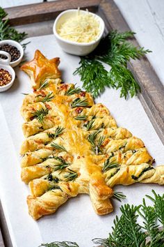 a pastry shaped like a christmas tree is on a tray with other holiday foods and condiments