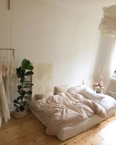 an unmade bed sitting on top of a wooden floor