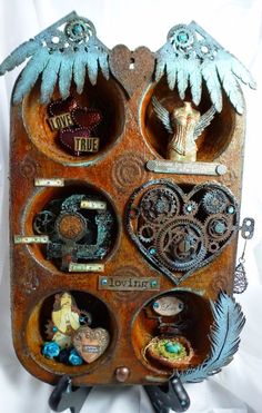 an old wooden box with many different items in it's compartments and some feathers on top