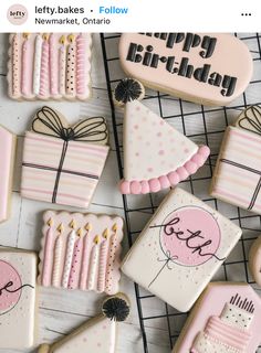 decorated cookies with pink and white icing sitting on a wire rack next to each other