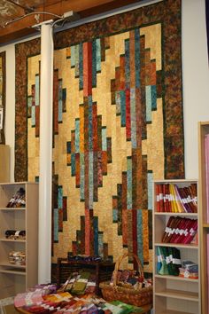 a room filled with lots of different types of quilts on the walls and shelves