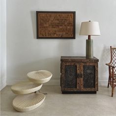 a living room with two chairs and a table in front of a painting on the wall