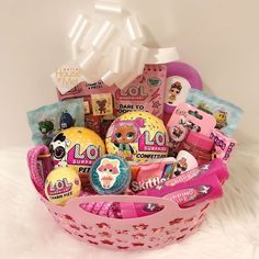 a pink basket filled with lots of different types of candies and other things in it