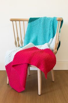 a crocheted blanket sitting on top of a wooden chair