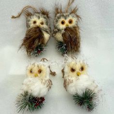 four fake owls are sitting on top of pine cones