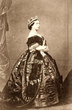 an old black and white photo of a woman in a dress with a tiara