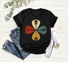 a t - shirt with an image of keys and arrows on the front, next to jeans