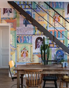 a dining room table with chairs under a stair case