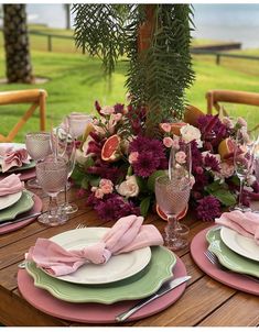 the table is set with pink and green plates