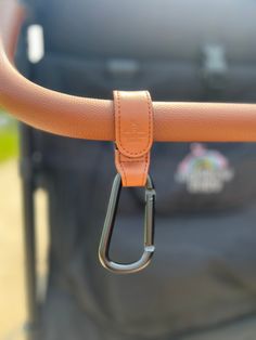 a close up of a caramel colored handle on a luggage bag with an orange leather strap