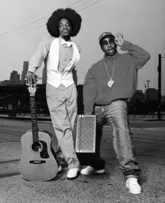 two men standing next to each other with guitars