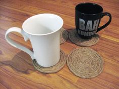 two black and white coffee mugs sitting on top of coasters